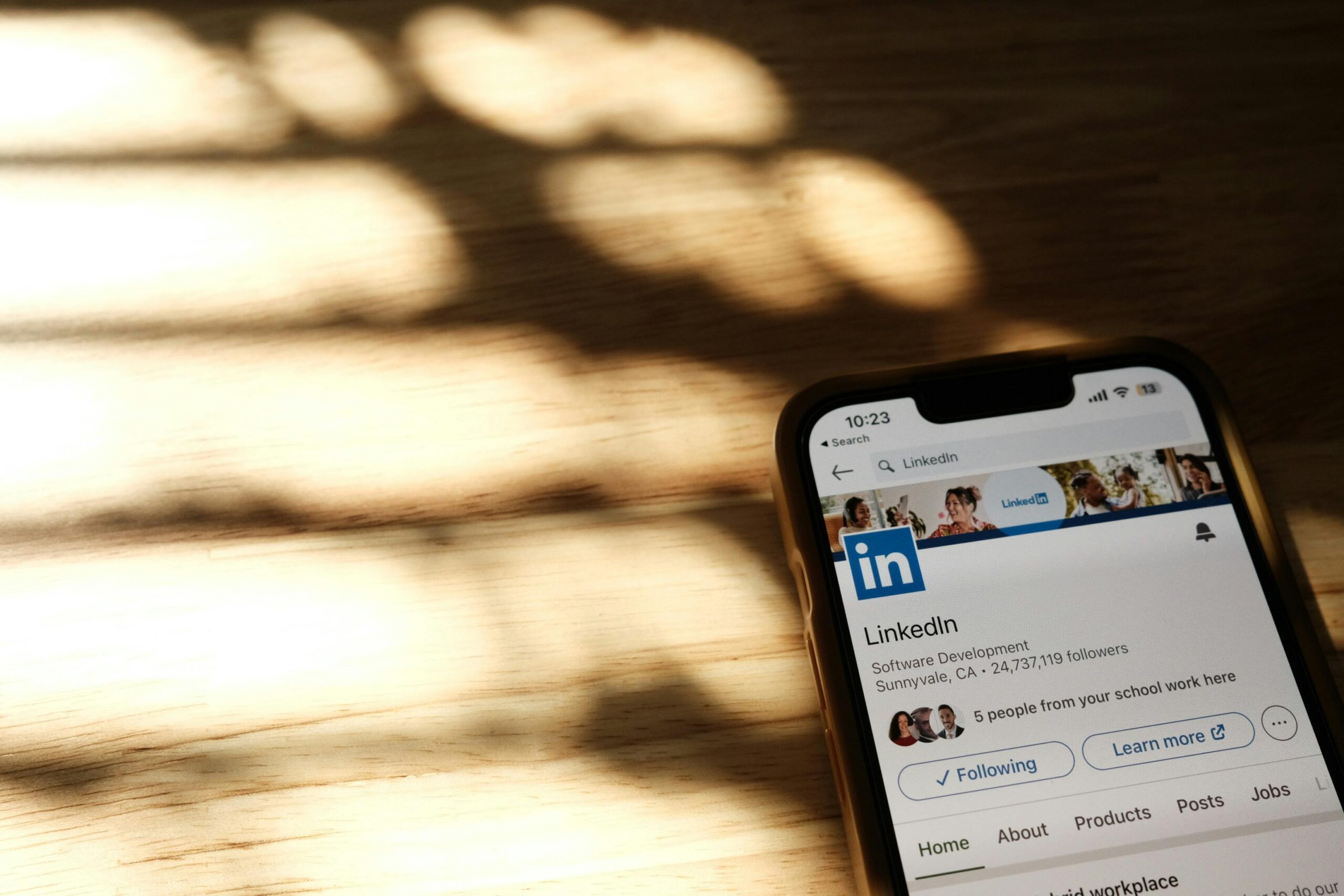 Profesional logrando crecimiento en LinkedIn usando laptop en oficina moderna