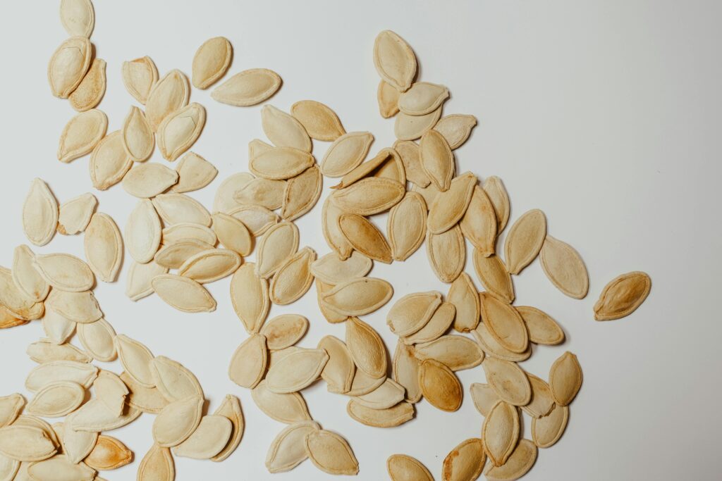 Close-up of pumpkin seed in a wooden bowl with fresh pumpkins