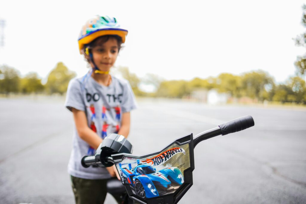 Child riding a safe and colorful bike for kids with helmet in park